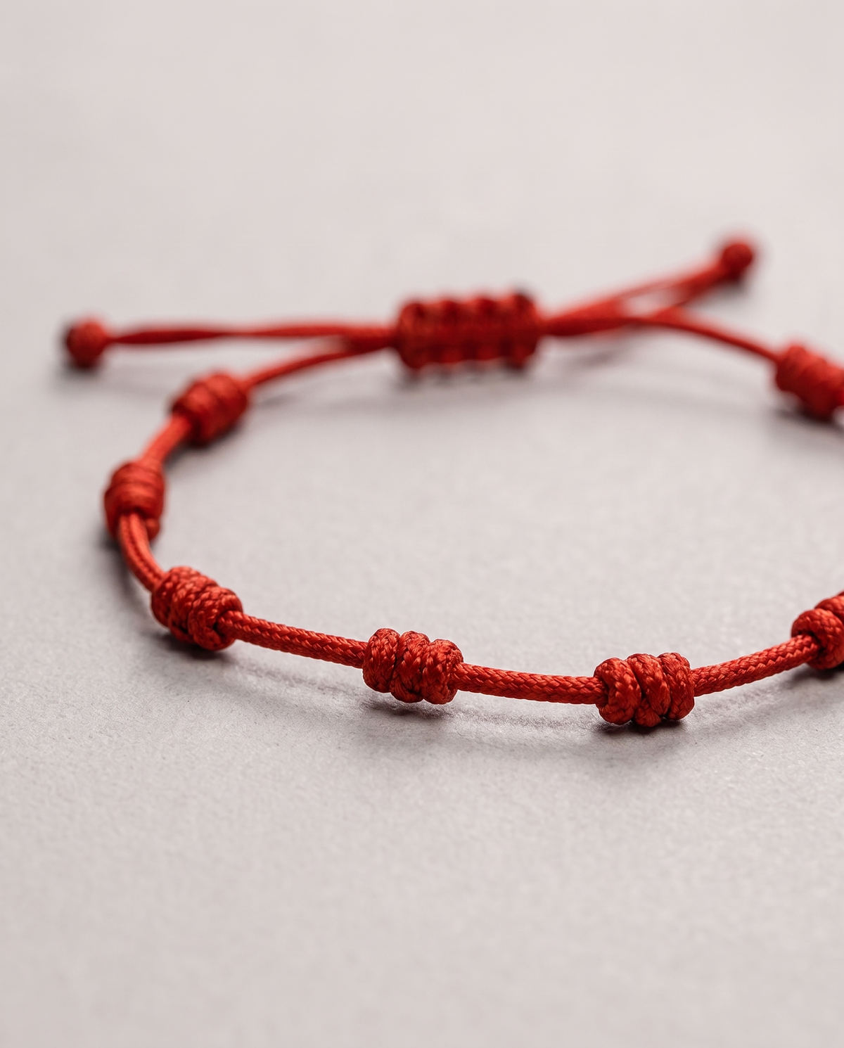 Close-up of the Barletta Knot red Supima cord bracelet showing the hand-tied knots
