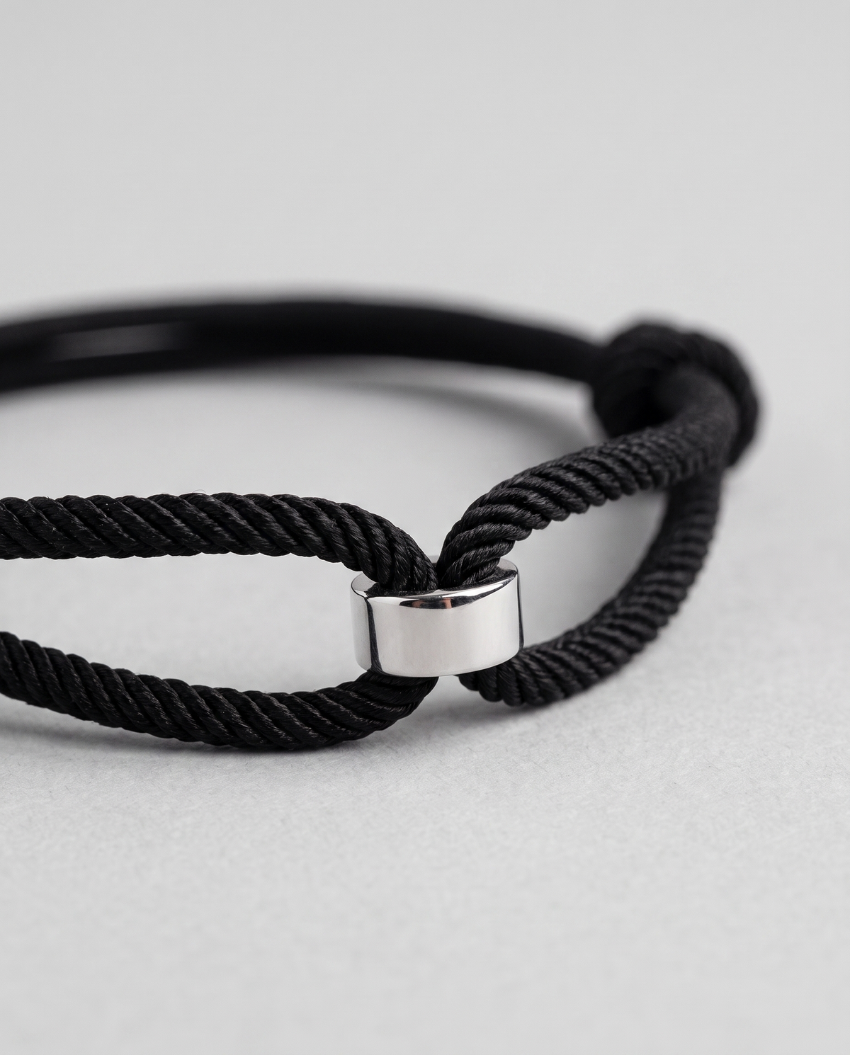 Close-up of the Milan Cord black twisted Italian cord bracelet with polished silver barrel centrepiece