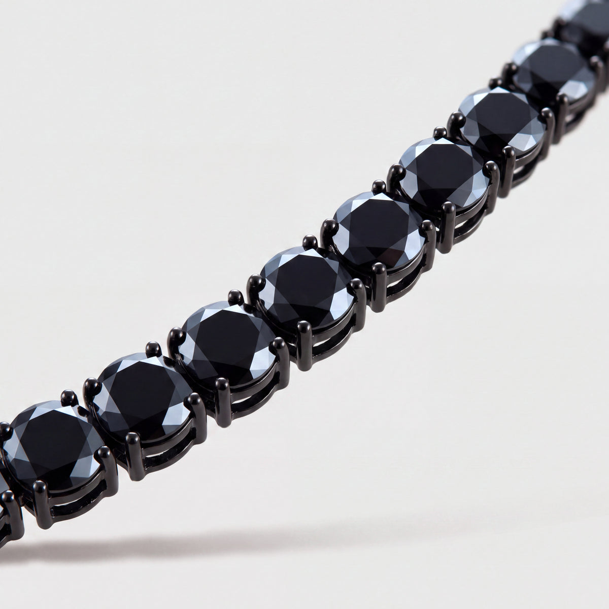 Macro detail of the Noir Chain's blackened prongs and black stones