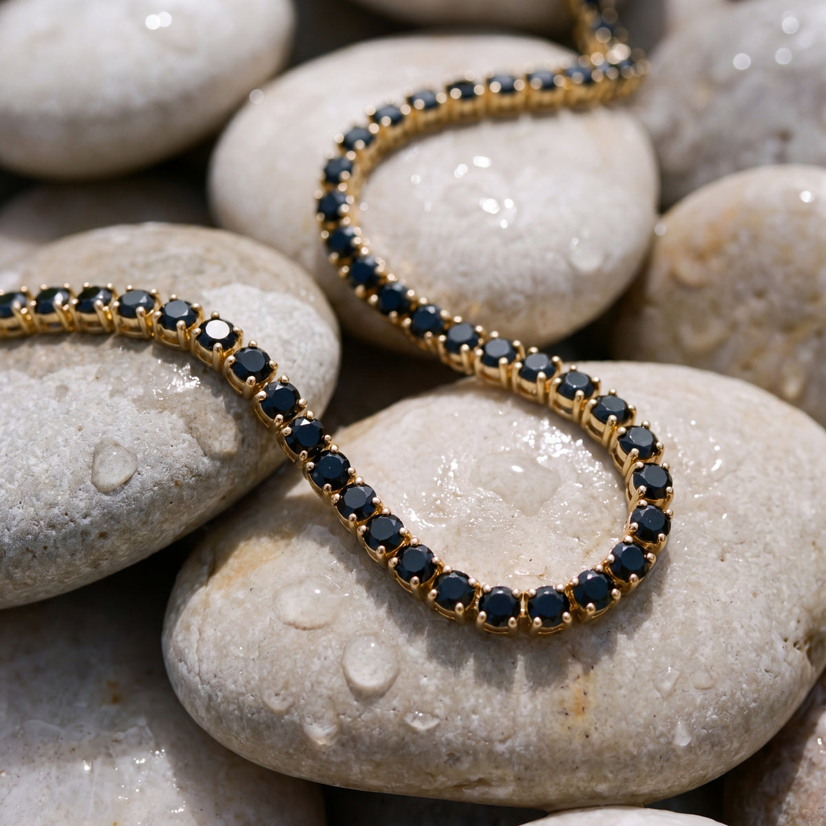 Onyx Dore Chain laid on smooth river pebbles