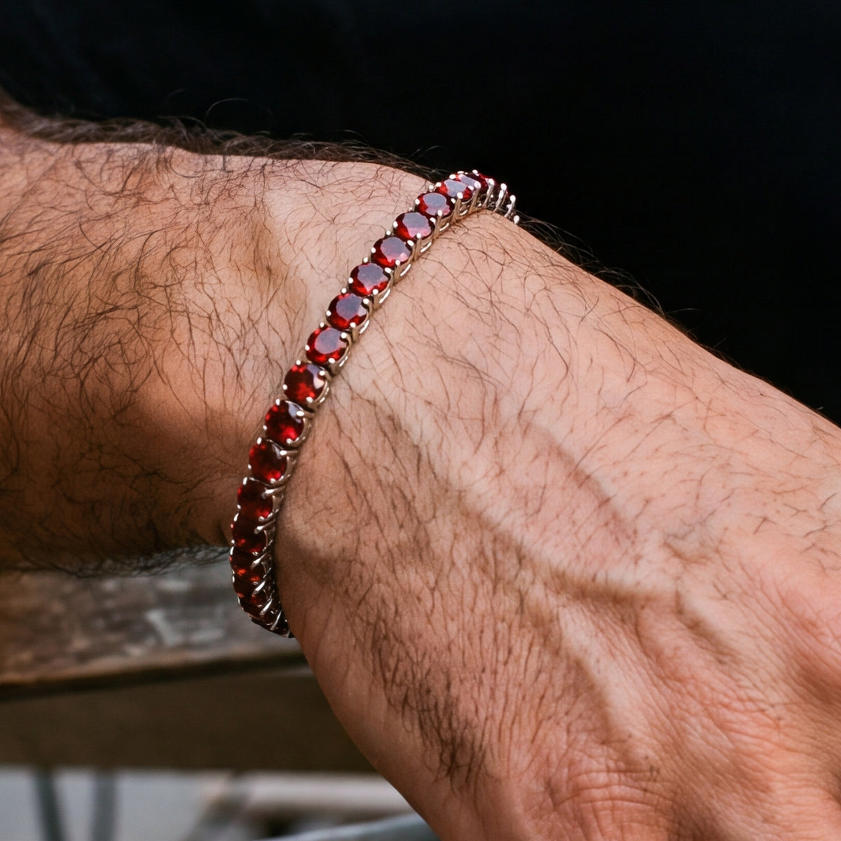 Close-up of the Rubi Garnet bracelet's deep red stones and prong setting on the wrist
