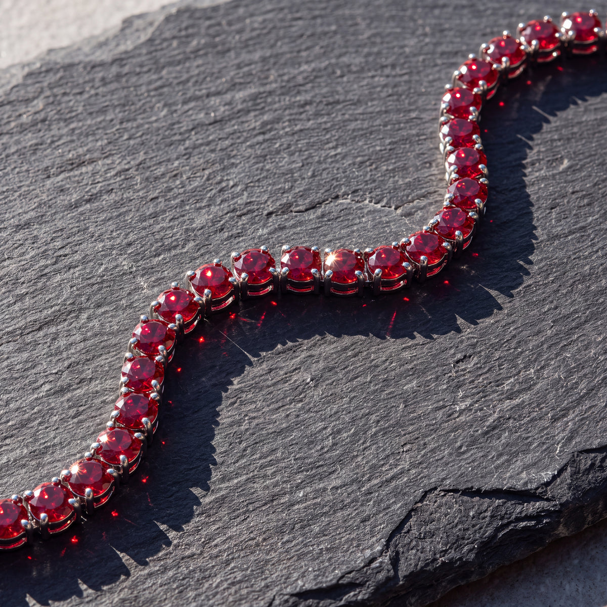 Rubi Garnet bracelet curving across dark slate